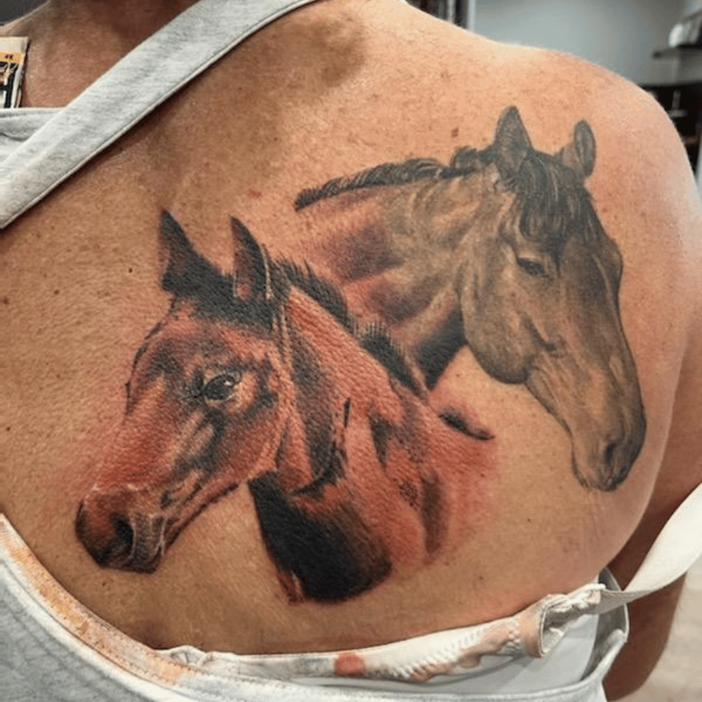 horses tattooed on a woman's upper back